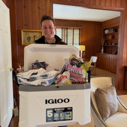 a man holding a cooler full of gifts