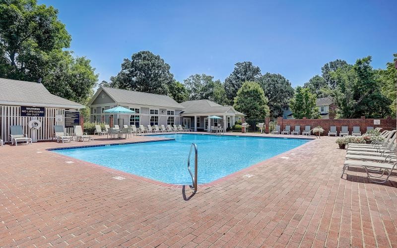 a swimming pool with a brick patio